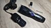 Electric hair trimmer with accessories on wooden table.